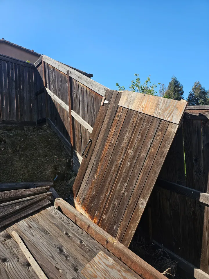 A wood fence collapsed off its posts along a Fresno property line, waiting on repair.